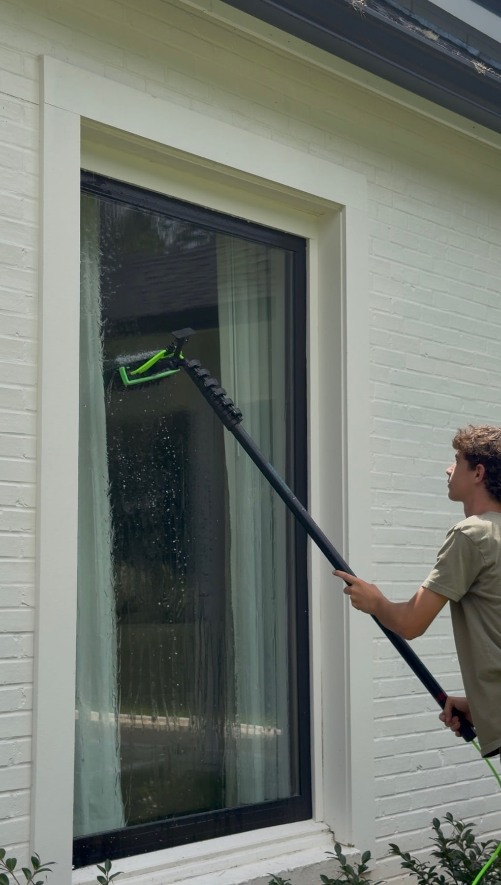 Brooks Safley cleaning an exterior window with an RODI water fed pole.