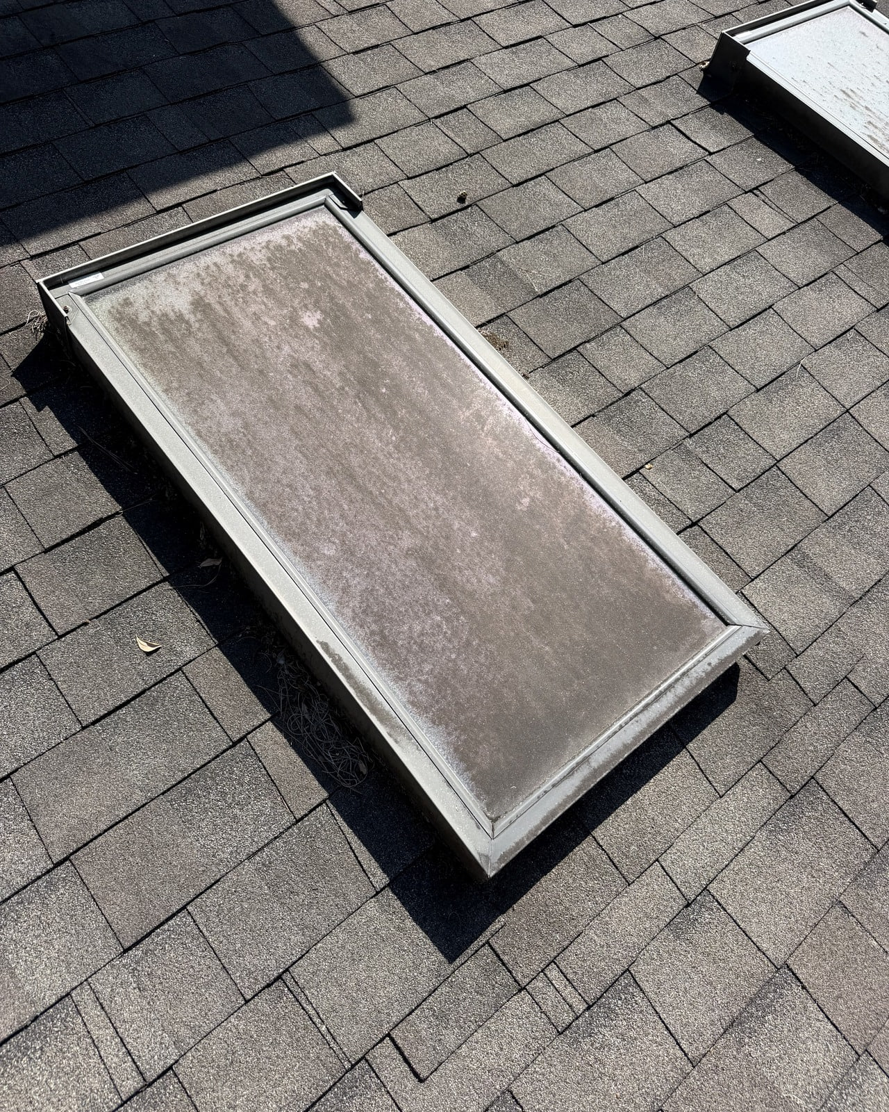 Rooftop glass covered in dirt before cleaning.